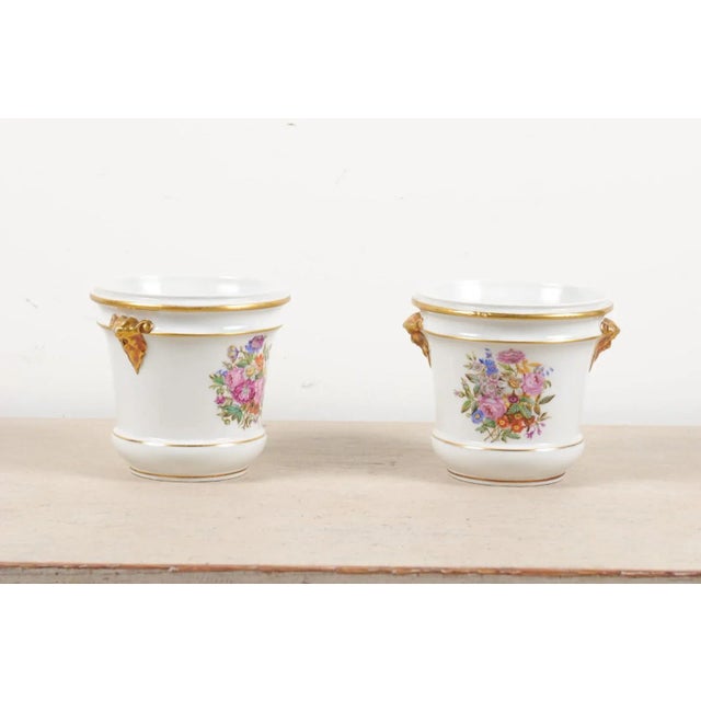 A pair of French Louis XVI period Paris porcelain cachepots from the late 18th century, with hand-painted floral décor and...