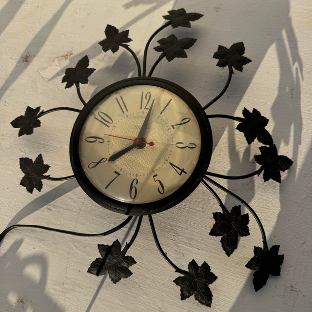 Metal United wall clock. Plug and play clock. Keeps perfect time. Appears to have a broken limb that wraps around the face...