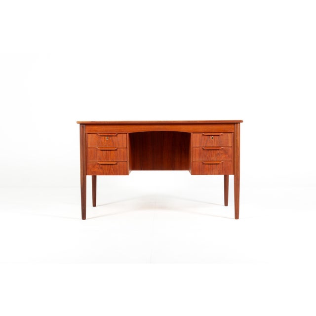A beautiful and elegant Danish writing desk from the 1960s, crafted in warm teak with a stunning natural grain. This...