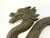 A striking vintage cast iron wall hook featuring a sinuous dragon in high relief, its scaled body winding across a cloud-...