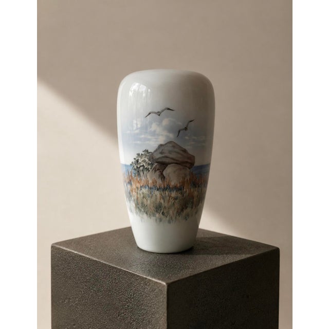 A stunning example of Royal Copenhagen’s celebrated naturalistic porcelain painting, this elegant vase wraps a fully...