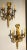 Set of four large and impressive Louis XVI style ornate three-light torch and ribbon form wall sconces. This listing is...