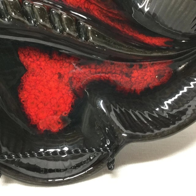 Iconic 1960s design in this large ceramic ashtray/catchall. Showcasing gloss black ceramic with bright, vibrant red sprays...