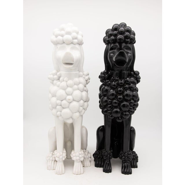 A delightful duo of composite lifesize Poodles, one ebony and one snowy white! Likely advertising models, these enchanting...