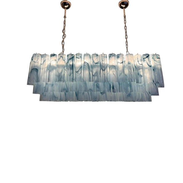 Monumental Italian chandelier in handblown blue Murano glass, designed with an elongated architectural silhouette and a...