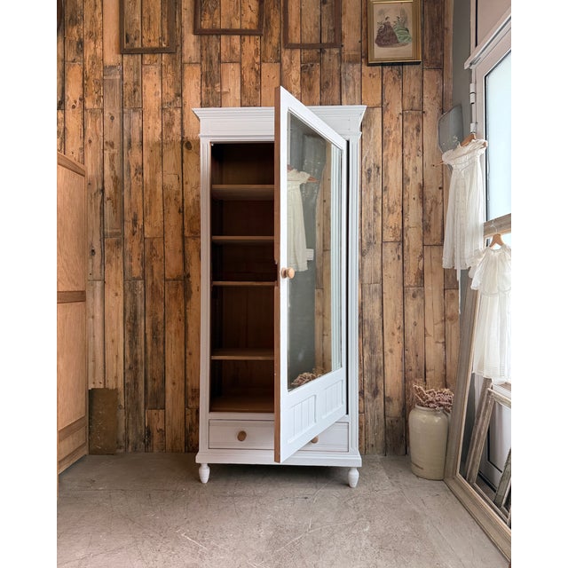 This elegant antique mirrored wardrobe captivates with its clean lines and luminous finish. With its large central mirror,...