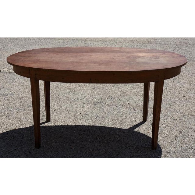 Oval table in solid cherry wood with pin base, neoclassical directoire style, italy, early 19th century. The table has an...