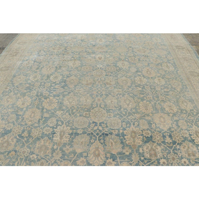 This 11x14 oversized antique Persian Tabriz rug, hand-knotted in wool and originating circa 1920-1940, is a graceful...