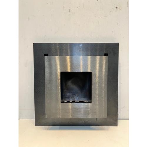 Sleek modern wall-mounted bio ethanol fireplace in brushed stainless steel with contrasting dark backing plate. The...
