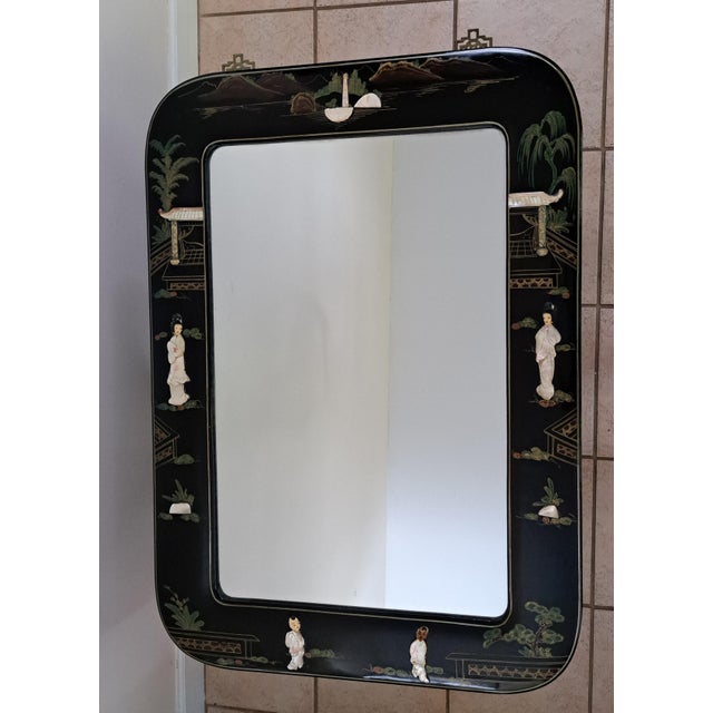 A beautifully crafted vintage Chinese Chinoiserie wall mirror featuring a lustrous black lacquer frame adorned with hand-...