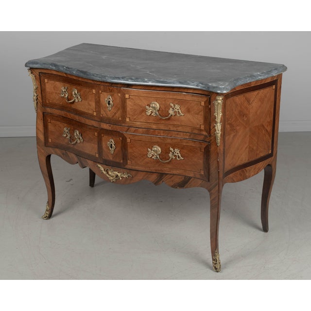 A fine 18th century French Louis XV Period marquetry commode sauteuse with a gentle serpentine curved front, slightly...