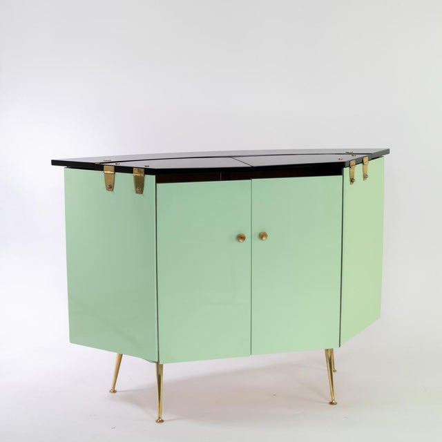 Hinged bar cabinet with ice compartment, painted in different colors with brass elements.