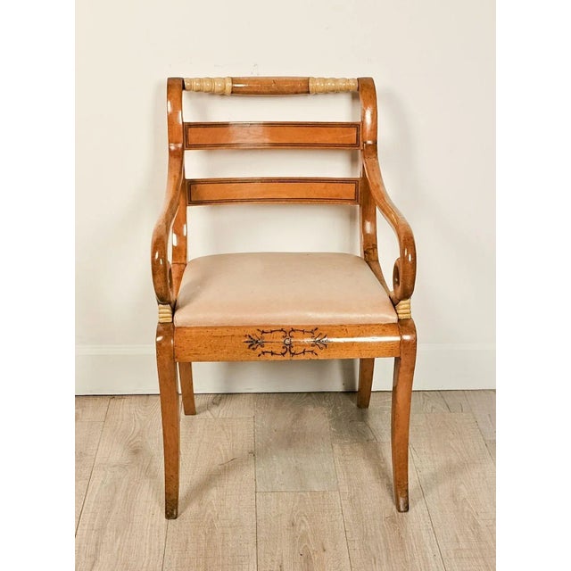 A satinwood inlaid armchair with painted cream-colored accents, France or Russia, circa 1825. Seat height 19.5".