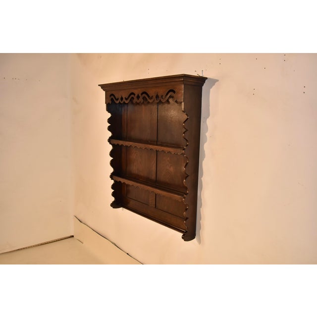 Late 19th century oak hanging wall shelf from England. On the top of the shelf there is a lovely crown molding, following...