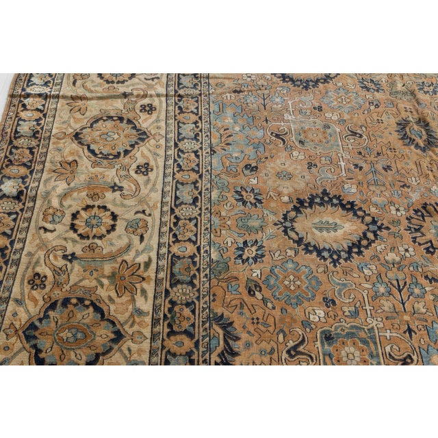 An early 20th century Persian Kirman (Kerman) antique rug, the camel field with a bold allover design of palmettes and...