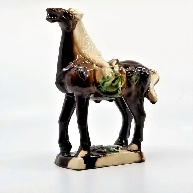 Offering a vintage ceramic Chinese horse figurine in the Tang Dynasty style, circa 1960s. This multi-colored glazed horse...