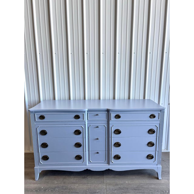 Classic French Provincial–style dresser refinished in a soft dusty blue, paired with dark bronze hardware for a more...