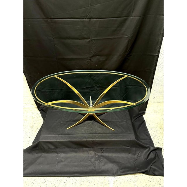 A very beautiful and rare brass table from the 1960s. The crossbar is exquisitely crafted, featuring a brass sphere...