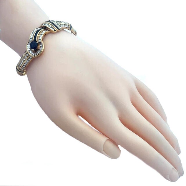 This stunning bracelet is crafted from 18k yellow gold featuring the front half in a fancy curved style with a pear shape...