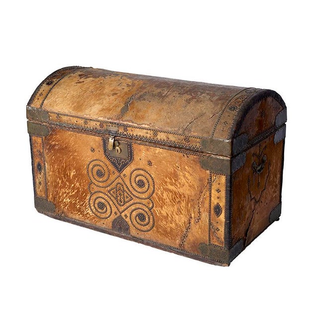 This monumental 19th century provincial chest includes a hide exterior with intricate stud patterning, and original...