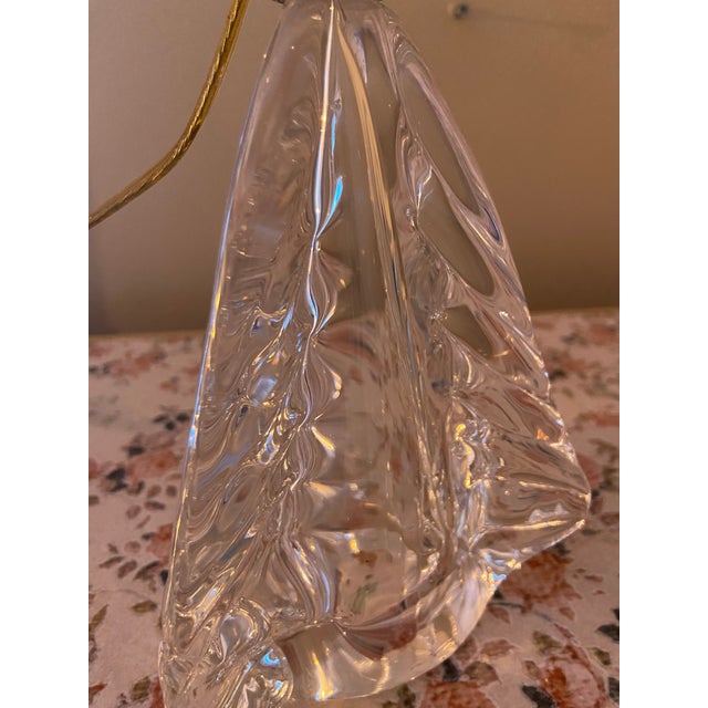 An elegant and distinctive decorative table lamp featuring a beautifully sculpted clear glass base with an unusual...