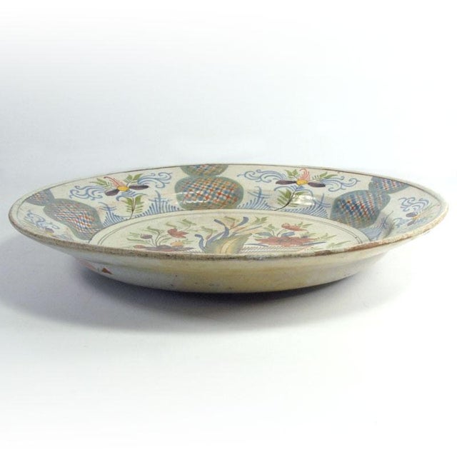 A large, impressive 19th-century plate/platter made of thick faience. Decorated throughout with hand-painted Delft-style...
