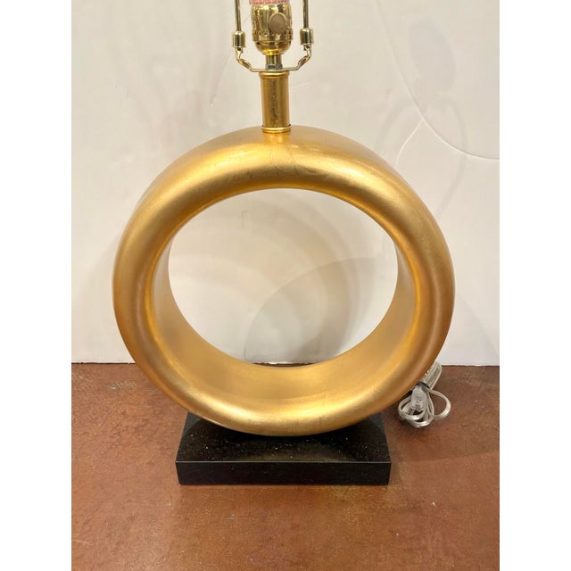 Modern Currey & Co Lamp. Gold ring body on black marble base. Showroom floor sample.
