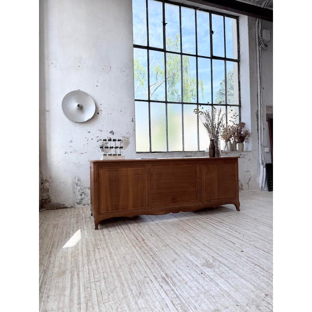 Vintage large oak desk or counter from the 1960s. we love its elegant look, with its paneled front, gently curved legs,...