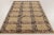 This 6x9 contemporary Scandinavian rug showcases a repeating geometric pattern in ochre, brown, mauve, and gray tones....