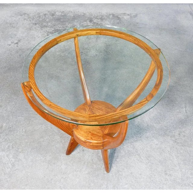Italian design coffee table in oak wood and circular glass top. Signed on the se bottom. Period 1953 author the table is...