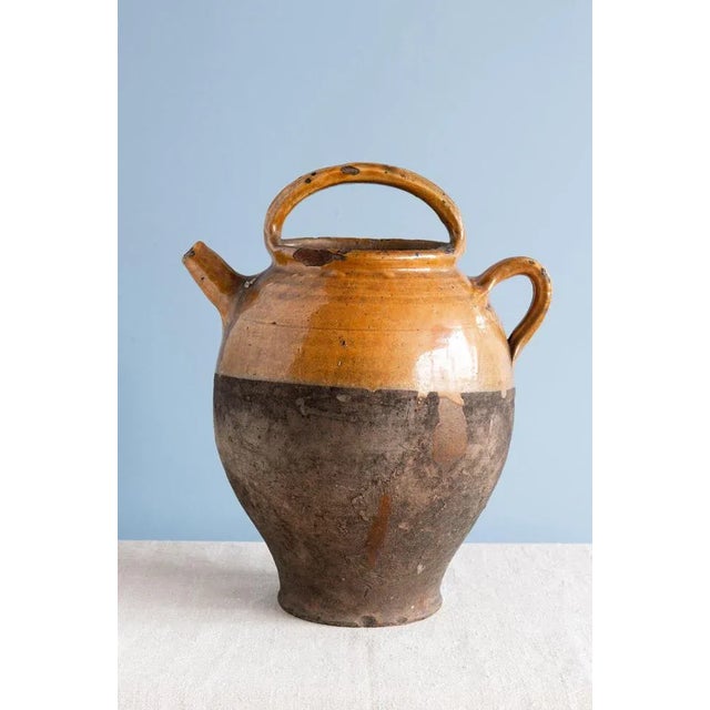 This 19th-century French pottery jug from Provence is decorated in a gorgeous ochre glaze and bare clay on the lower part....