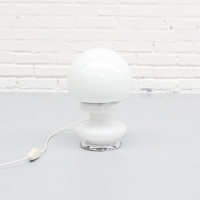 Italian 1970s table lamp made of hand-blown white opal glass with elegant chrome details. European Plug (up to 250V).The...