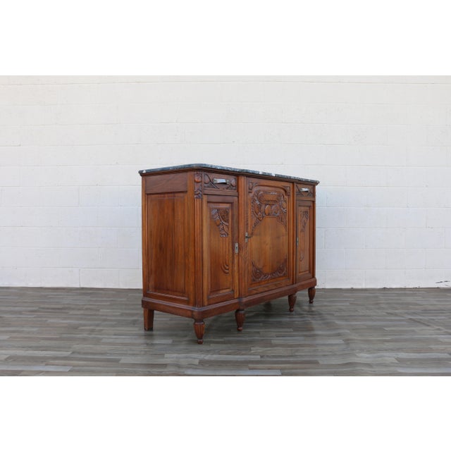 A beautiful Antique French Art Deco marble-top sideboard, dating to the 1920s, showcasing exceptional craftsmanship and...