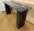 Striking post modern black marble console table is crafted from richly veined black marble and boasts a sleek rectangular...