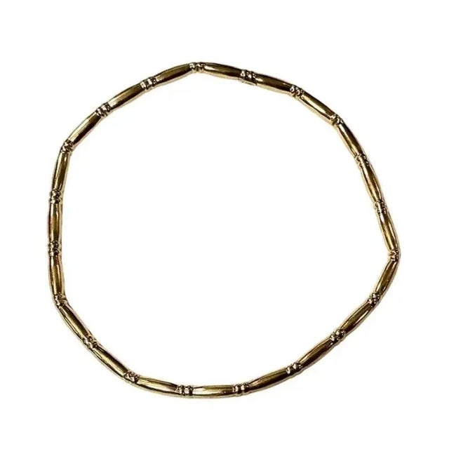 Timeless 14K Gold Bangle Bracelet designed in a bamboo-style motif. Bracelet features a seamless circular design composed...