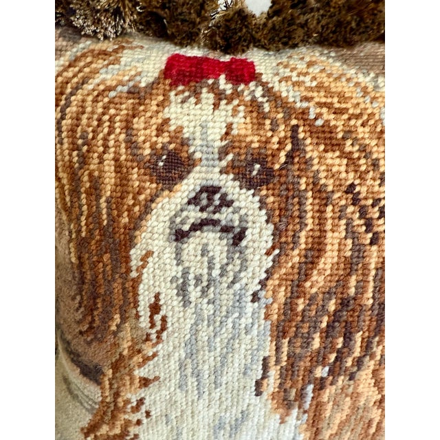 Here is a charming needlepoint pillow featuring a Shih Tzu dog with red bow in her hair. The dog has brown and white fur....