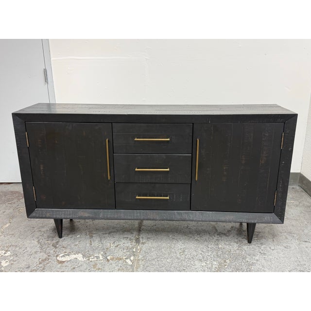 Design Plus Gallery presents the Alexa Media Console by West Elm. This console has a black wood grain surface with a...