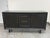 Design Plus Gallery presents the Alexa Media Console by West Elm. This console has a black wood grain surface with a...
