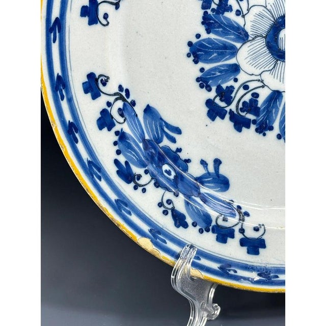 Dutch Delft blue and white plate, 18th century, the centre decorated in cobalt oxide with flowers, the rim with stylised...