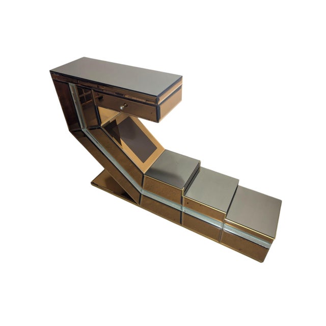 A space-age console table with smoked mirrors and gold-plated brass accents, dating back to the 1970s and 1980s. It...