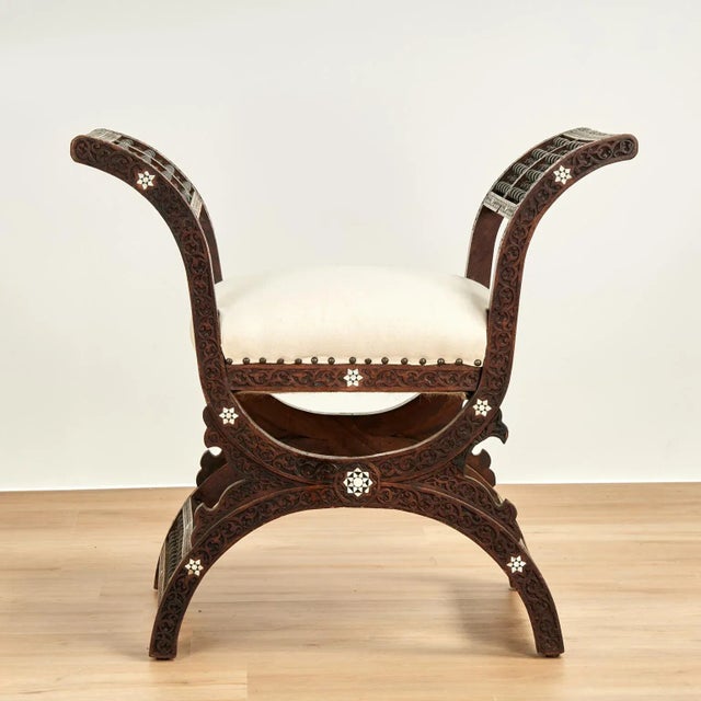 Enchanting antique Moroccan bench crafted in walnut in a classic moorish form featuring floral carvings, stick and ball...