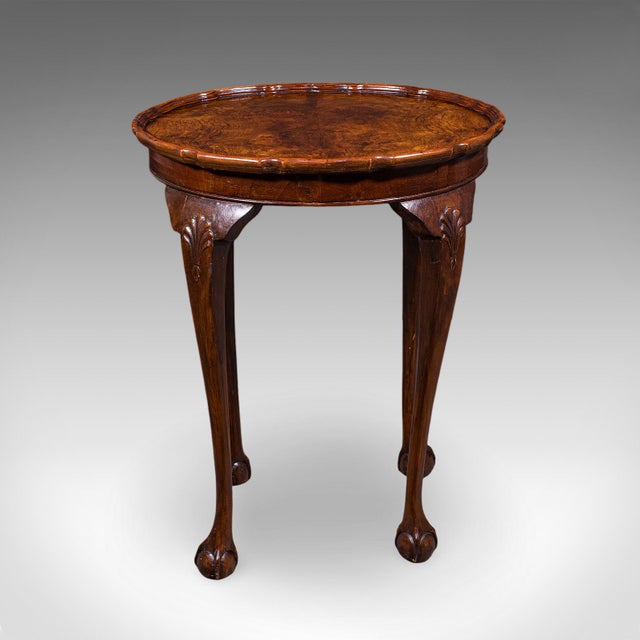 This is an antique oval side table. An English, burr walnut and beech lamp or wine table with pie crust top, dating to the...