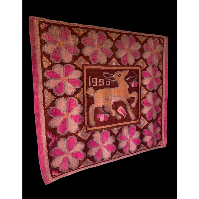 This striking Peruvian tapestry is a dated 1990 example of Andean folk art weaving, featuring a bold central deer motif...