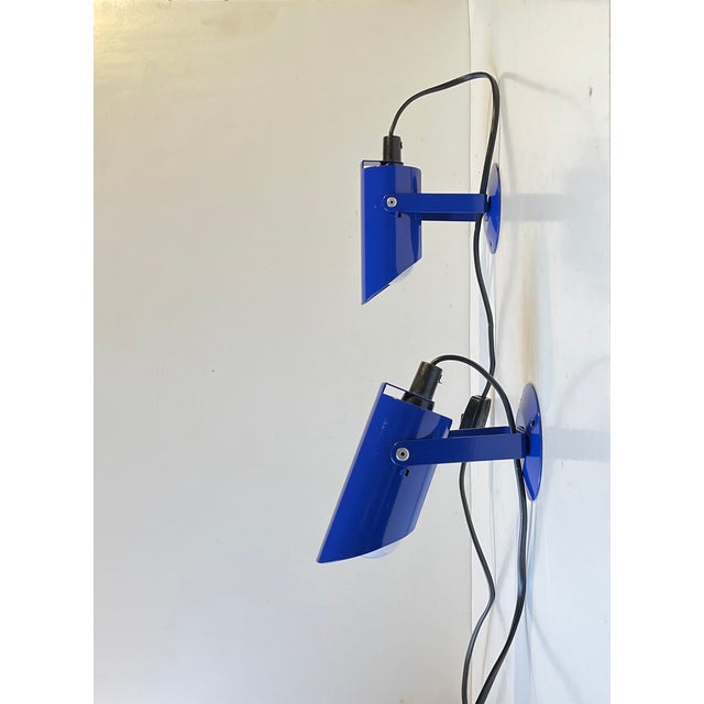 A pair of clean pointy wall lamps made from blue powder coated steel. Designed and manufactured by Lyfa in Denmark. For...