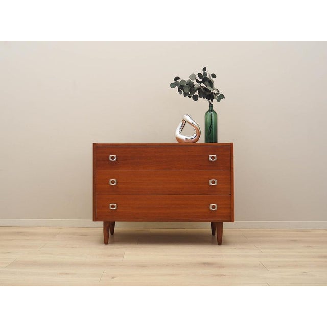 The chest of drawers was made in the 1970s in Denmark. The structure is covered with teak veneer. The legs are made of...