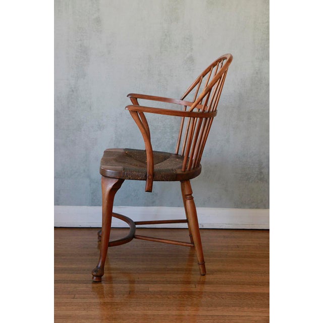 This is a classic antique Windsor armchair from the early 19th century. It features a hooped bow-back with vertical...