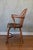 This is a classic antique Windsor armchair from the early 19th century. It features a hooped bow-back with vertical...