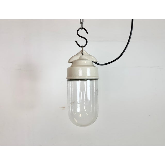 Vintage industrial light made in former Czechoslovakia during the 1970s. It features a white porcelain top and a glass...