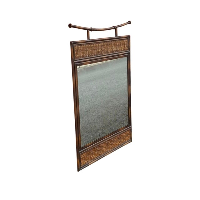 A 20th Century Pagoda Style Faux Rattan Metal and Wicker Wall Mirror Dimensions: 24.25 inches wide. .75 inches deep. 36.25...