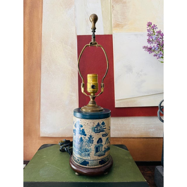 A beautifully scaled Wildwood table lamp featuring a cylindrical tin base wrapped in a blue willow inspired chinoiserie...